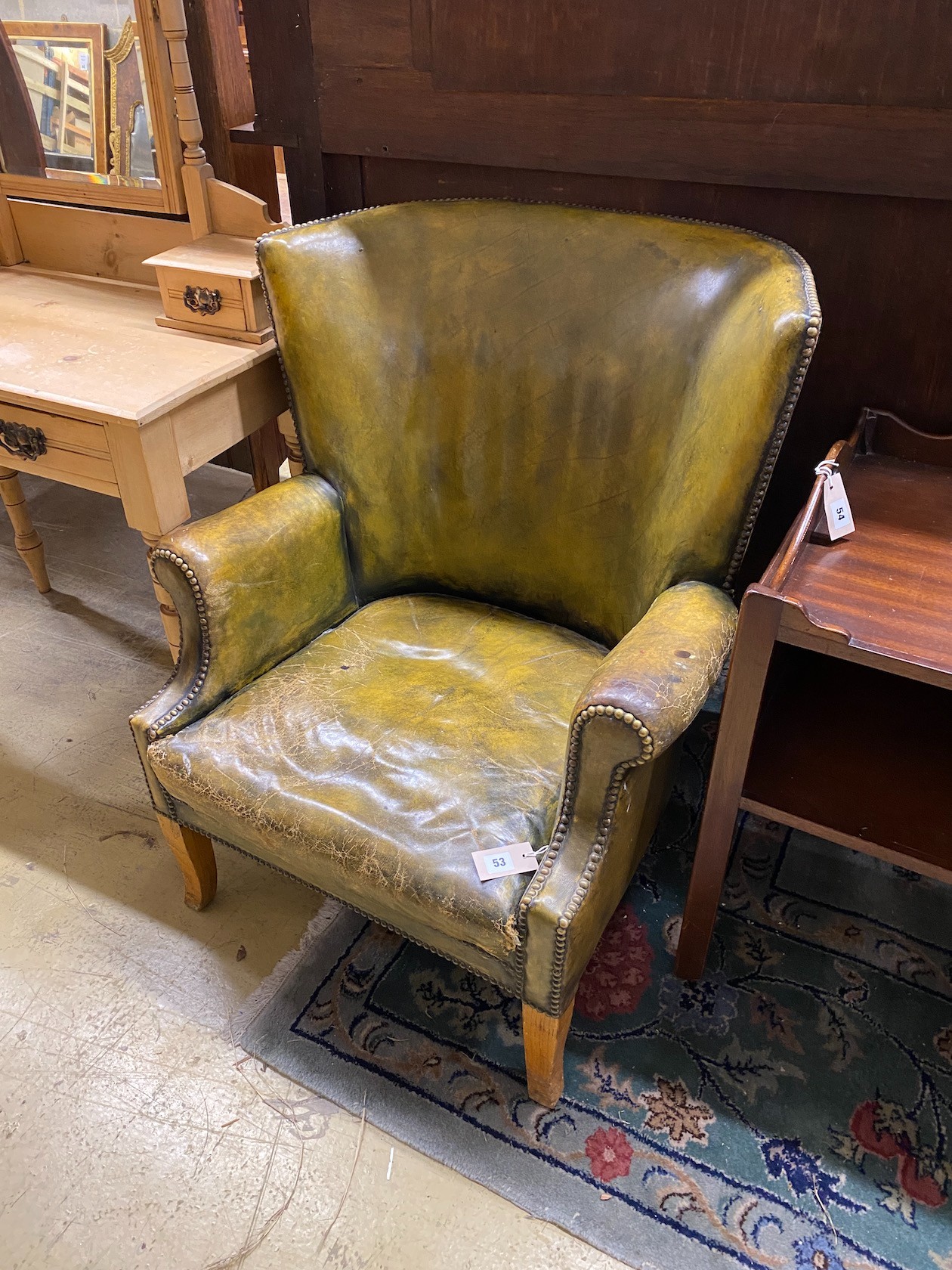 A green leather library armchair, width 73cm, depth 78cm, height 89cm